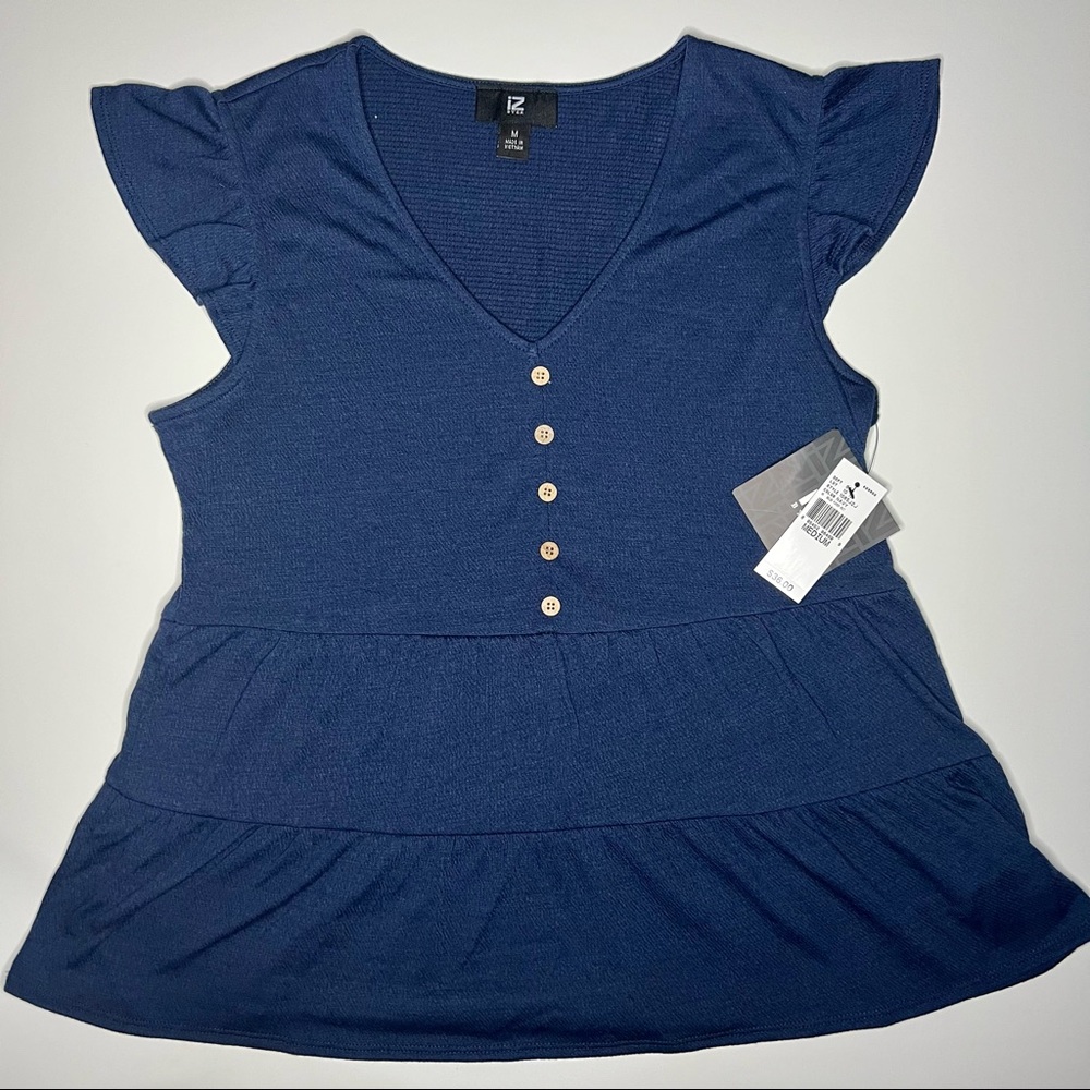 Tiered baby doll style top with decorative buttons.
